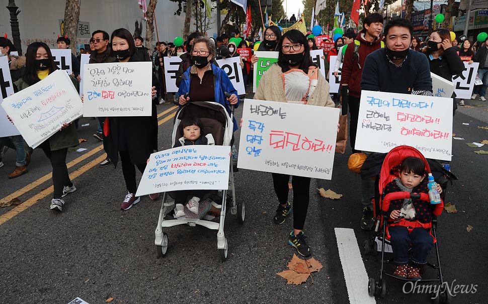  유모차에 아이를 태우고 나온 시민이  12일 오후 서울 종로구 대학로에서 '최순실 게이트'로 불거진 국정농단 사태에 대해 박근혜 대통령의 하야를 촉구하며 민중총궐기 대회에 참가하기 위해 거리행진을 벌이고 있다.
