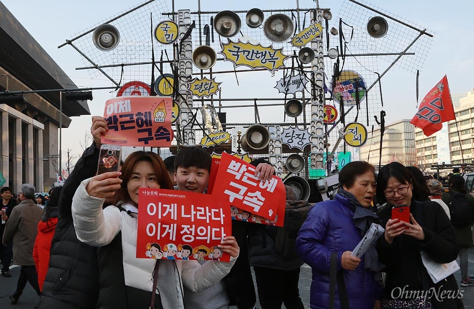 촛불승리 만끽하며 기념사진 찍는 시민들 11일 오후 서울 종로구 광화문광장에서 열린 '모이자! 광화문으로! 촛불 승리를 위한 20차 범국민행동의 날'에 참석한 시민들이 박근혜 대통령 파면을 자축하며 기념사진을 찍고 있다.
