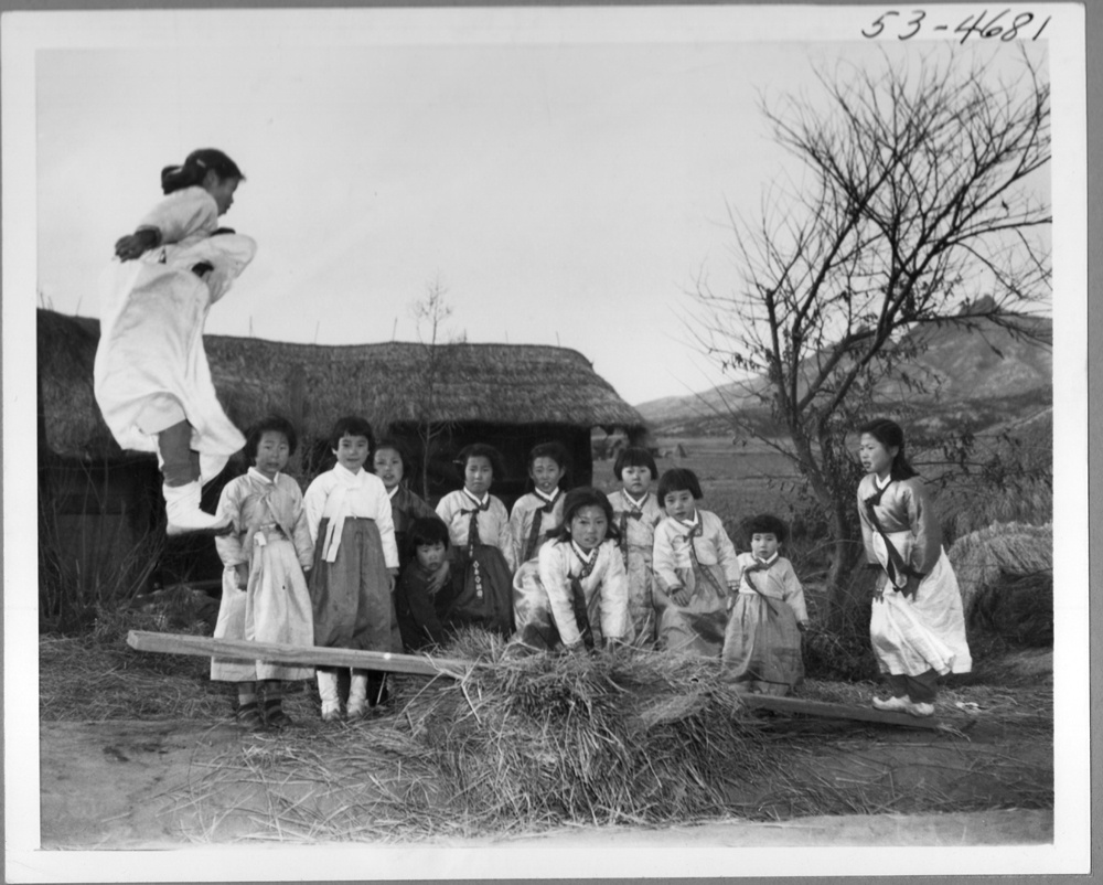  1953.2.19. 전란 중이지만 설빔을 차려 입은 천진난만한 소녀들이 민속놀이의 하나인 널뛰기를 하고 있다.