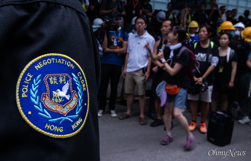 '폭력진압' 대신 투입된 협상 경찰 17일 오전 범죄인 인도법(일명 송환법) 폐지를 촉구하는 ‘검은 행진’에 참가한 홍콩 시민들에게 경찰들이 도로점거 철수를 요구하고 있다. 지난 12일 '폭력진압'으로 국제사회의 이목이 집중되어 경찰은 강경한 대응을 하지 않았다.  
