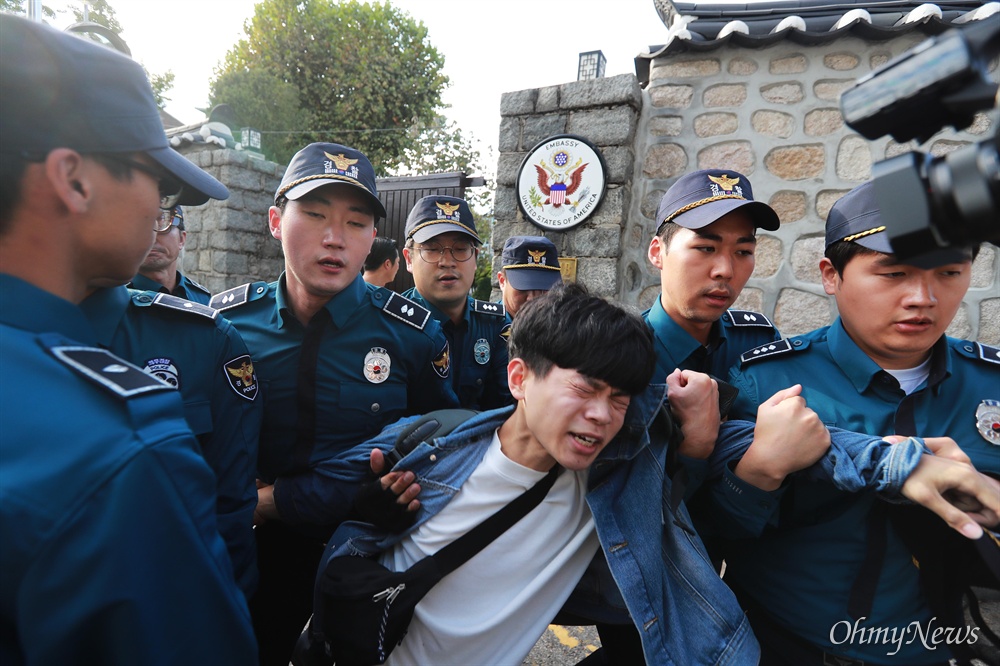 방위비 분담금 항의, 미대사관저 '월담' 기습시위 한국대학생진보연합 소속 대학생들이 과도한 주한미군 방위금 분담금(6조) 요구에 항의하며 18일 오후 서울 중구 덕수궁 뒤편 미대사관저 담장에 사다리를 놓고 넘어들어가는 기습 시위를 벌였다. 사다리를 이용해 미대사관저에 들어갔던 대학생들이 경찰에 의해 끌려나오고 있다.