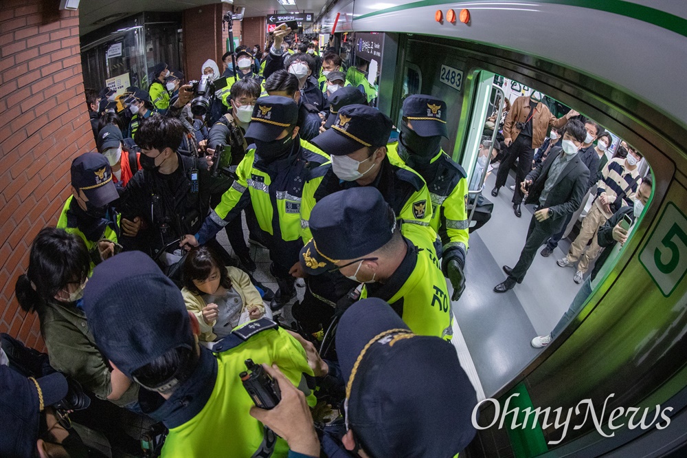  전국장애인차별철폐연대 활동가들이 21일 오전 서울 중구 2호선 시청역사 내에서 지하철 탑승시위를 하고 있다.