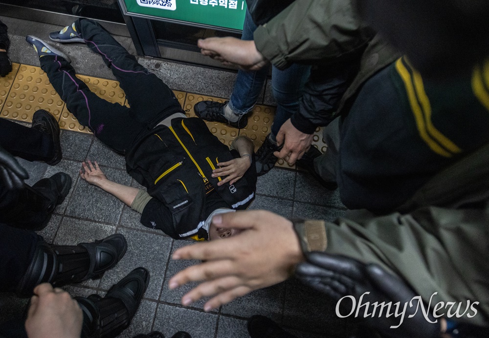 전국장애인차별철폐연대 활동가들이 21일 오전 서울 중구 2호선 시청역사 내에서 지하철 탑승시위를 하자 경찰이 저지해 바닥에 쓰러져 있다. 