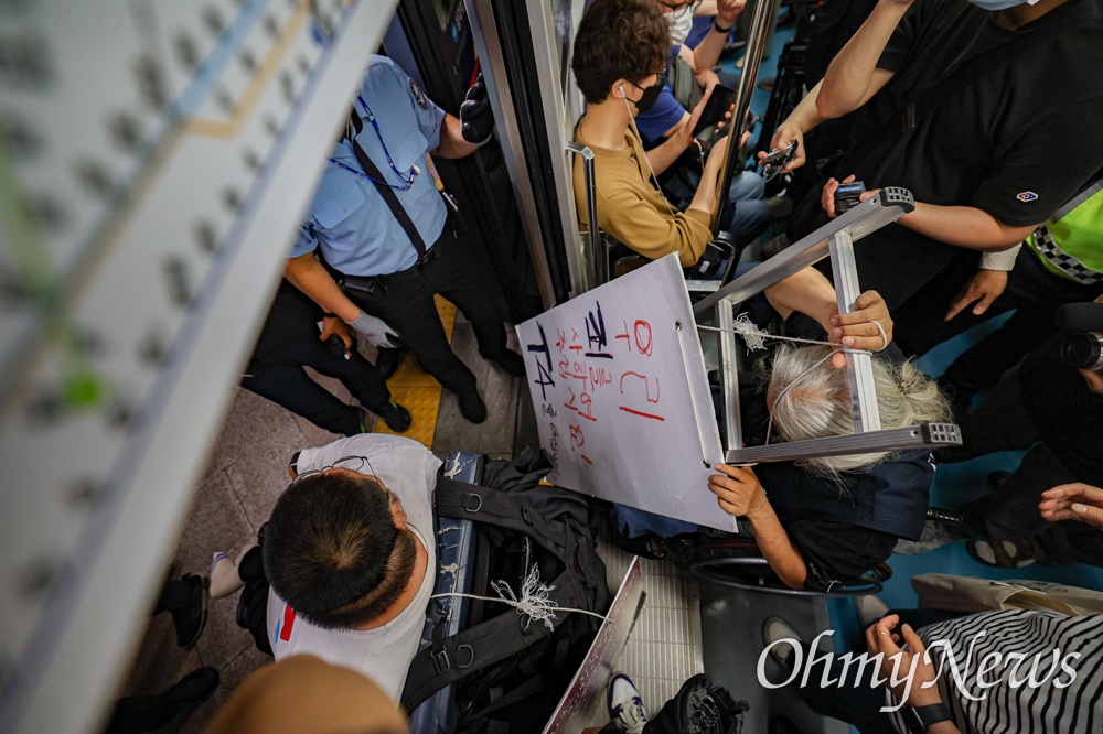  전국장애인차별철폐연대 활동가들이 13일 오전 서울 종로구 혜화역에서 장애인권리예산 반영을 위해 ‘제 29차 출근길 지하철탑니다’ 탑승 시위를 하고 있다.