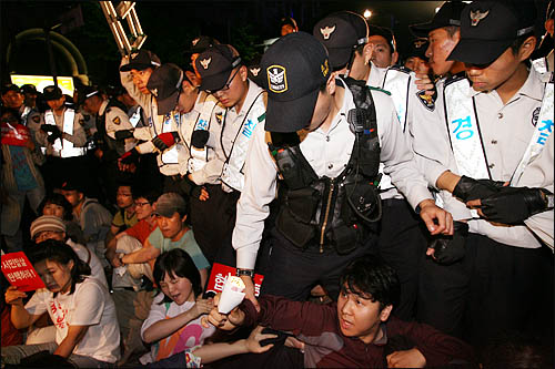 미국산 쇠고기 수입에 반대하는 촛불문화제에 참석했던 학생과 시민들이 24일 밤 행사를 마친 뒤 청와대로 행진하려다 경찰에 가로막혀 종로 거리를 점거한 채 연좌농성을 벌이고 있다.