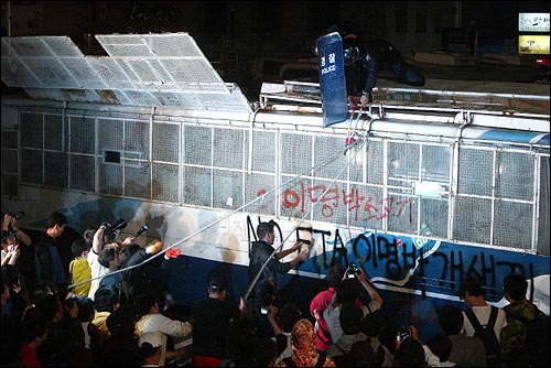 미국산 쇠고기 수입 전면 개방 반대 72시간 릴레이 농성 세 번째날인 7일 새벽 서울 신문로 한글회관 앞에서 시민, 학생들이 경찰버스를 끌어내려 하자 절단기를 든 경찰이 밧줄을 끊으려 하고 있다.
