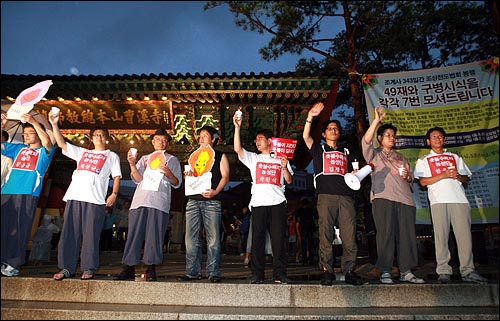 12일 저녁 광우병국민대책회의 주최 범국민촛불문화제에 참석한 시민들이 조계사앞을 지나가자 대책회의 수배자들이 일렬로 서서 시민들을 향해 손을 흔들고 있다.