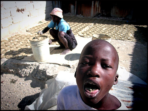 아들은 먹고 어머니는 말리고. 가난이 만들어 낸 아이티의 자화상이다.