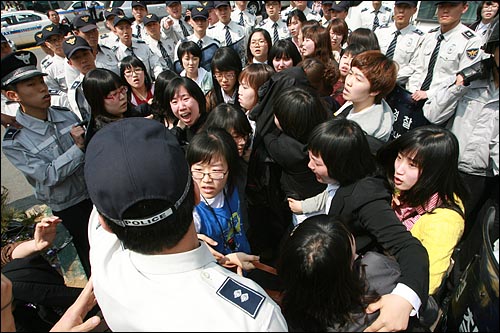 여대생들이 경찰에 둘러싸여 있다.