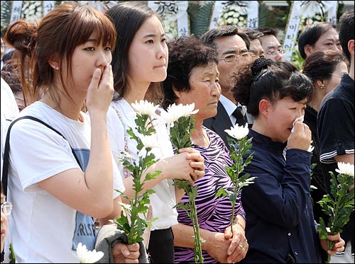 노무현 전 대통령 서거 사흘째인 25일 오후 경남 김해 봉하마을회관 앞에 마련된 분향소를 찾은 추모객들이 순서를 기다리며 눈물을 흘리고 있다.