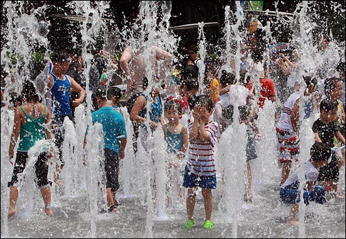 연일 30도가 넘는 무더운 날씨가 계속되는 가운데 4일 오전 서울 광화문 광장 찾은 어린이들이 분수대에서 더위를 식히며 물놀이를 하고 있다.