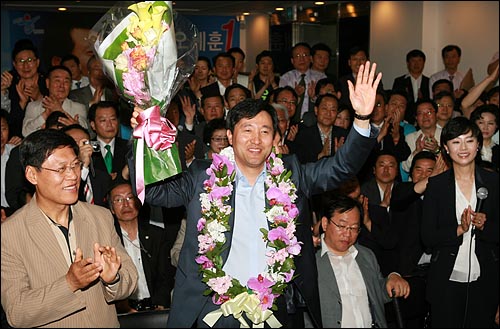 재선에 성공한 오세훈 서울시장이 2010년 6월 3일 오전 서울 중구 프레스센터 선거사무실에서 지지자들에게 둘러싸여 축하 꽃다발을 들고 있다.