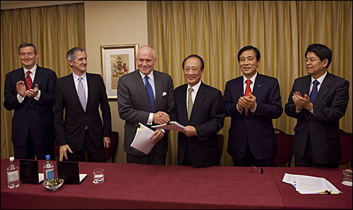 지난 2010년 11월 25일 오전 11시 영국 런던의 한 호텔에서 김승유 하나금융 회장(오른쪽에서 세 번째)과 존 그레이켄 론스타 회장(왼쪽에서 세 번째)이 외환은행 지분 인수를 위한 주식매매계약서에 서명하고 있다.