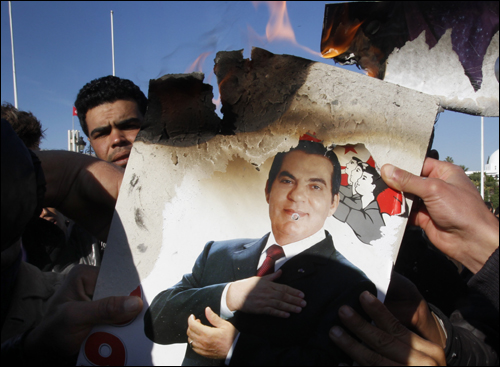 지난 2011년 1월 24일 튀니지 수도 튀니스에서 시위대가 벤 알리 전 대통령의 사진을 불태우고 있다. 