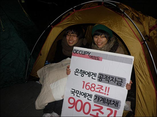 서강대학교 부총학생회장 김윤영씨(오른쪽)가 한국거래소 앞 Occupy 텐트안에서 피켓을 들고있다. 