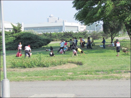 교회로 가는 평양시내 길. 잔디 위에서 아이들이 뛰어 놀고 있다.