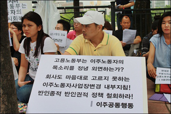 집회에 참석한 이주노동자가 고용노동부를 규탄하는 피켓을 들고 있다.