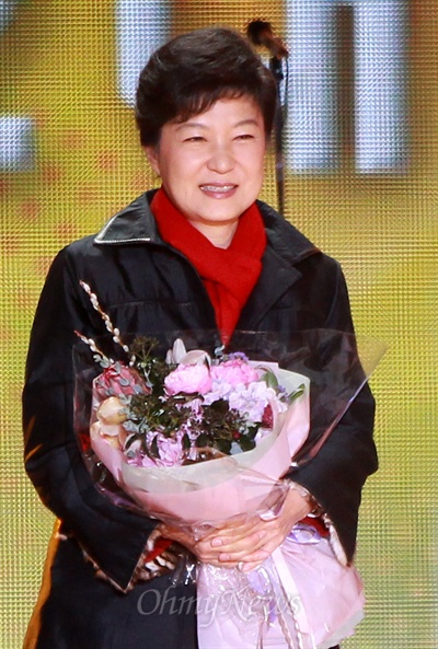 제18대 대통령선거가 치뤄진 19일 오후 박근혜 새누리당 대선후보가 당선이 확정적인 가운데 서울 광화문광장에서 열린 방송사 생방송 무대에서 축하 꽃다발을 받고 있다.