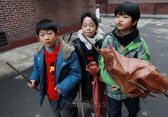  '성대골 마을학교' 아이들이 22일 오후 서울 동작구 상도동 국사봉 등산로에서 찾은 나뭇가지를 손수 들고 마을학교로 향하고 있다. 포대 자루를 든 남자 아이들은 "힘든 일은 매일 남자들만 한다"며 웃음기 섞인 불만을 토로했다. 