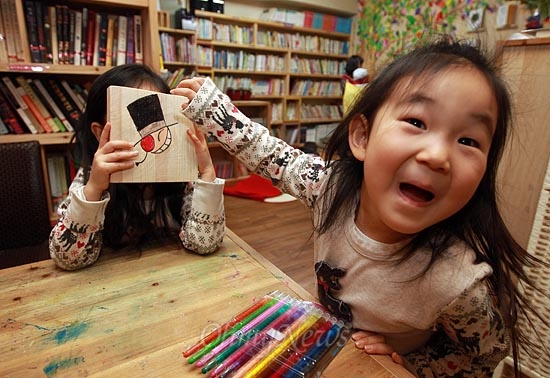 25일 오후 서울 용산구 효창운동장 인근 어린이 도서관 '고래이야기'에서 아이들이 나무 조각에 그린 그림을 자랑하며 즐거운 시간을 보내고 있다.