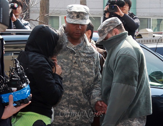 지난 3월 2일 주한미군이 서울 도심에서 총기 난동을 부리고 도주한 사건이 발생한 가운데, 4일 오후 서울 용산구 용산경찰서에서 도주차량에 함께 탔던 미군 C모 하사 부부가 미군 인솔자(가운데)와 함께 경찰 조사를 받기 위해 출두하고 있다.