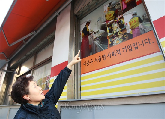 신수동 행복마을 주식회사를 운영했던 이평심 회장이 25일 오후 서울 마포구 신수동 가게 외벽에 붙여 있는 사진을 보여주며 지난 2010년 서울시 사회적 기업에 선정돼 음식점이 번창했던 이야기를 하고 있다.