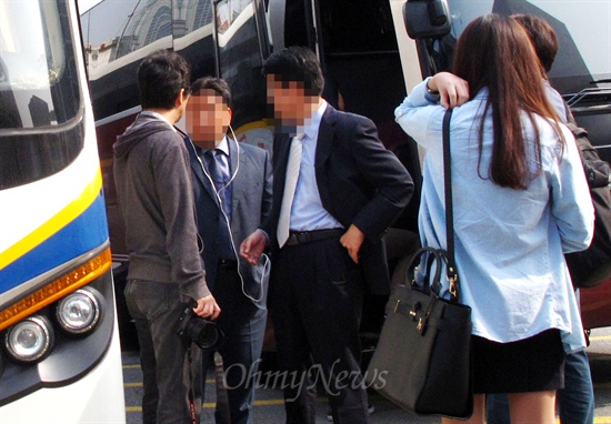24일 오전 서울역광장에서 국정원 안보특강에 참석하는 사람들의 버스 탑승 모습을 한 기자가 촬영하자 국정원 직원이 기자에게 거칠게 항의하고 있다.