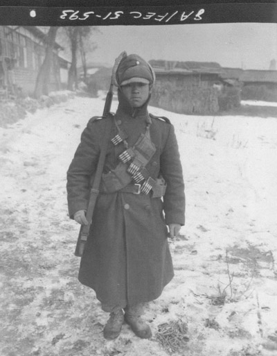 문제의 89번 사진: 한 국군의 차림으로 신발, 겉옷, 모자는 한국제이고, 코트와 무기(M1소총) 그리고 실탄은 미제다(1951. 1. 5.). 