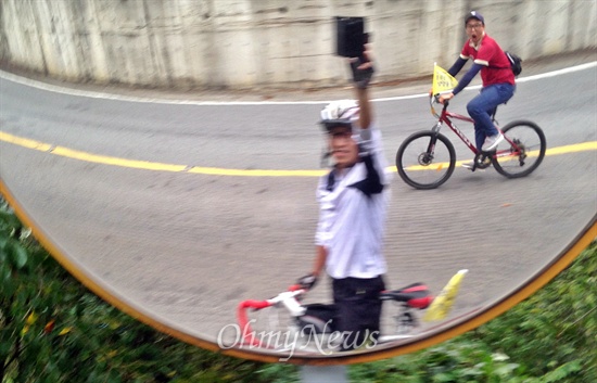 오마이리버 취재팀이 7일 오후 무척산을 내려오며 찍은 사진. 정대희 시민기자가 자전거를 멈춰 세우고 거울 앞에서 사진을 찍는 와중에 소중한 기자가 마침 지나가다 사진에 담겼다.
