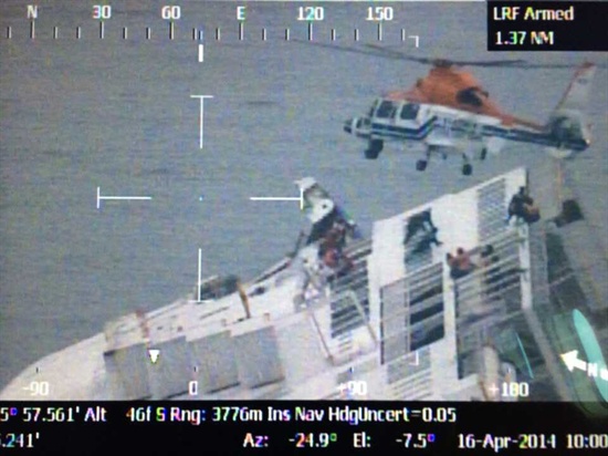 헬기가 기울어진 선체에서 빠져나오는 승객들을 구조하고 있다.