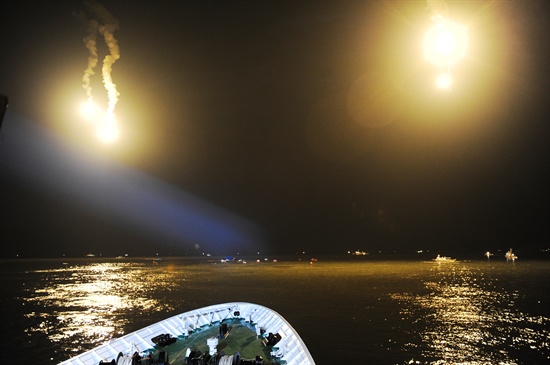 16일 오후 진도 인근 해역에서 침몰한 '세월호'  주위에 조명탄을 쏘아올리며 야간 수색작업이 진행되고 있다.