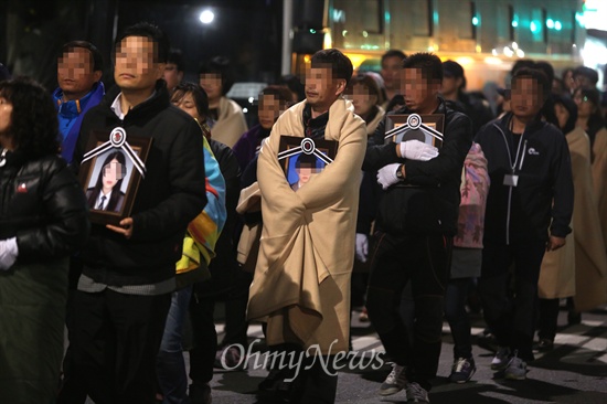 세월호 참사 유가족들이 안산 합동분향소에서 가져온 영정사진을 품은 채 9일 새벽 박근혜 대통령 면담을 요구하며 청와대를 향해 걸어가고 있다.