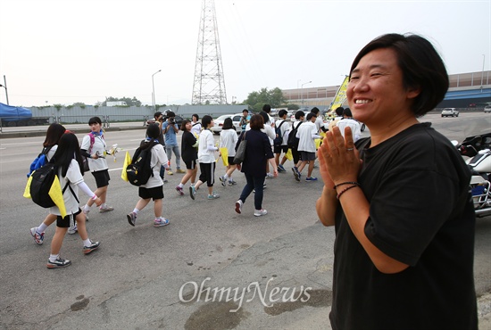 세월호침몰사고 생존 단원고 학생들이 15일 경기도 안산에서 국회를 향해 도보 행진을 하는 가운데 한 시민이 학생들을 응원하고 있다.