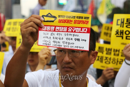 집회에 참석한 한 유가족이 대통령 면담을 요구하는 글을 적은 손 피켓을 들고 있다.