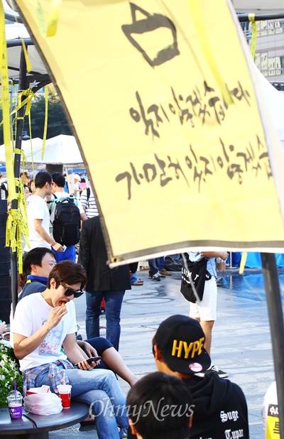 일베 회원등이 세월호 진상규명 특별법 단식농성장 앞에서 '도시락 나들이' 등 먹거리 집회를 예고한 6일 오후 서울 광화문광장 농성장 주변에서 한 남성이 치킨을 먹고 있다. 