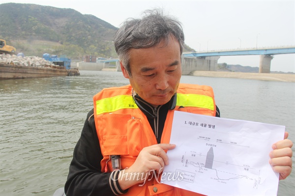  박창근 가톨릭관동대학교 교수(토목공학)가 12일 낙동강 창녕함안보 상하류의 침하 현상을 측량하기에 앞서 도면을 들어 보이고 있다.