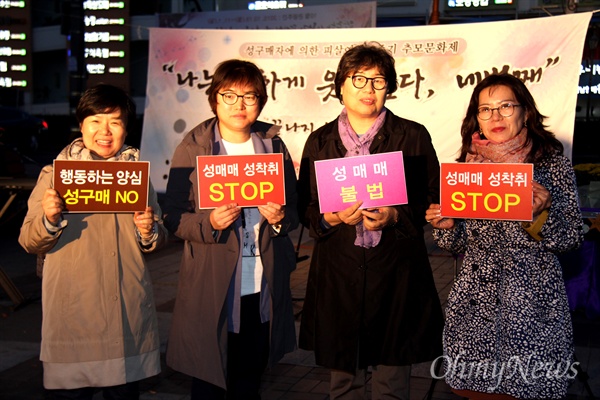 30일 저녁 창원 상남동 분수광장에서 열린 '성구매자에 의한 피살 여성 4주기 추모문화제'에서 참가자들이 성매매 근절 손팻말을 들고 서 있다.