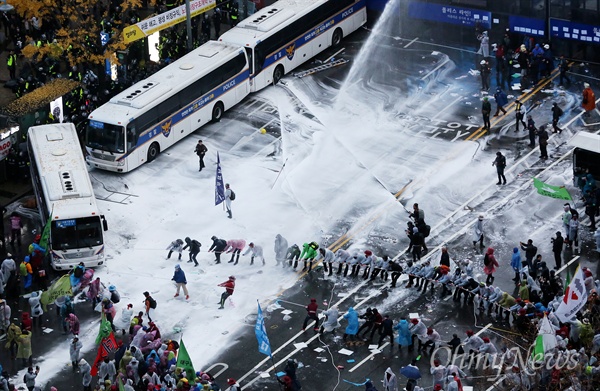 14일 오후 서울 광화문에서 열린 민중총궐기 대회에 참석한 참가자들이 차벽을 세워진 경찰버스를 당기고 있다. 경찰은 물대포를 쏘며 이를 저지하고 있다. 