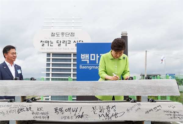 박근혜 대통령이 2015년  8월5일 강원도 철원 백마고지역에서 열린 경원선(용산-원산) 남측구간 복원공사 기공식에 참석해 사인을 하고 있다. 왼쪽은 홍용표 통일부 장관.
