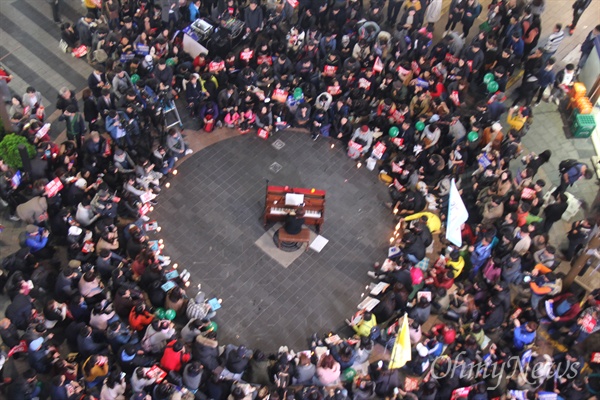 19일 오후 부산 서면에서 '박근혜 퇴진 시민대회'가 열리기 전, 박근혜정부에서 문화예술계 블랙리스트에 올랐다고 한 피아니스트가 거리에서 피아노 연주를 하자 둘레에 많은 시민들이 몰려 들었다.