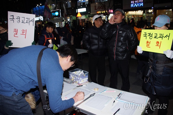  전국에서 유일하게 국정 역사교과서 연구학교로 지정된 문명고 학생과 학부모들이 25일 오후 대구에서 열린 박근혜 퇴진 시국대회에 참석해 시민들에게 서명을 받고 있다.