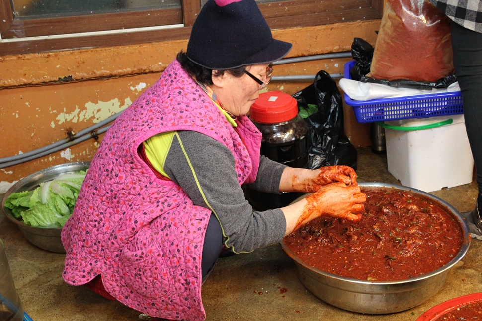  서귀포 올레시장 함평수산의 할머니가 자리돔 젓갈을 담고 있다.