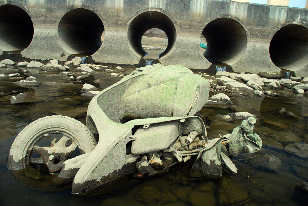  4대강 사업으로 건설된 충남 공주시 쌍신공원. 물이 빠지면서 버려진 오토바이가 녹조를 잔뜩 뒤집어쓰고 나타났다.