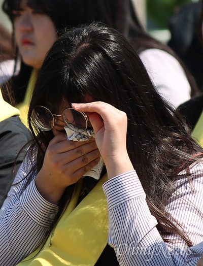  세월호 참사 3주년을 맞이해 16일 오전 진도 팽목항에서 열린 추모행사에 참석한 학생이 눈물을 닦고 있다. 