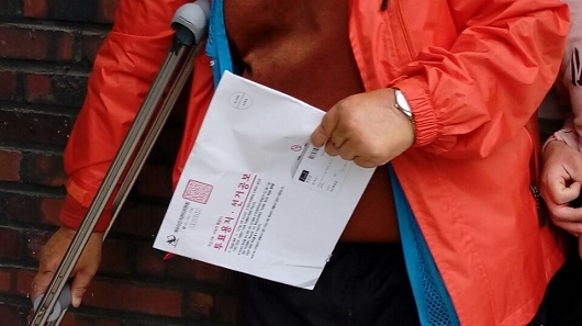 거소투표지 봉투 여수지역의 한 시설 장애인이 우편으로 배달받은 거소투표 봉투를 들고 투표소로 향하고 있다 