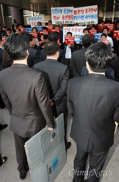  검찰이 'PD수첩'의 미국산 쇠고기 보도와 관련해 8일 오전 MBC본사 압수수색을 시도한 가운데, 출입구를 봉쇄한 MBC 노조원들과 검찰 수사관들이 대치하고 있다. 