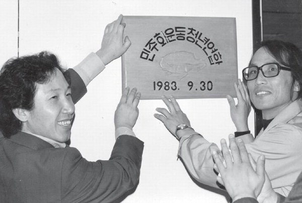  1983년 10월 29일, 사무실 입주식에서 김근태 의장과 장영달 부의장이 현판을 달고 있다. 