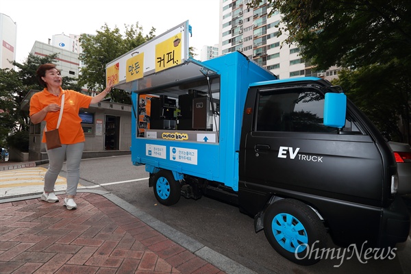 서울 동작구 신대방동 현대아파트 허정자 입주자대표회의 총무가 기자에게 ‘태양이 만든 커피’를 소개하고 있다. 경트럭 ‘라보’를 개조한 전기자동차 위에는 태양광 패널이 설치되어 커피 머신을 작동시킨다.
