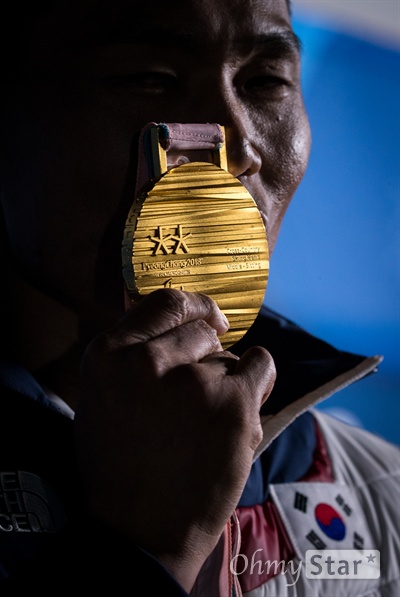  노르딕스키 신의현 선수가 17일 오후 강원도 평창 올림픽메달플라자에서 열린 크로스컨트리 남자 7.5km 좌식 부문 수상식에서 받은 금메달을 기자들에게 보여주고 있다.