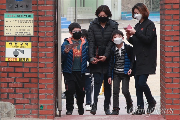 수도권 고농도 미세먼지 비상저감조치 시행 이틀째인 27일 오후 서울 마포구 한 초등학교에서 마스크를 착용한 학부모와 어린이가 하교를 하고 있다.